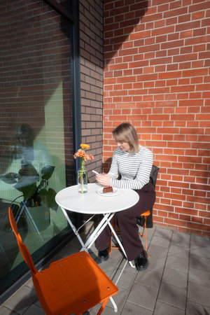 young woman with phone in cafe outdoorの写真素材