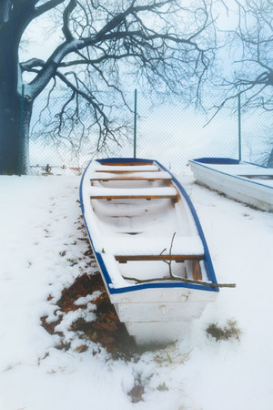 blue winter landscape with wooden boats in snowの写真素材