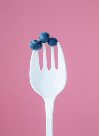 blueberries on a large white plastic forkの写真素材