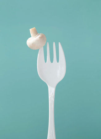 champignon on big white fork on green backgroundの写真素材