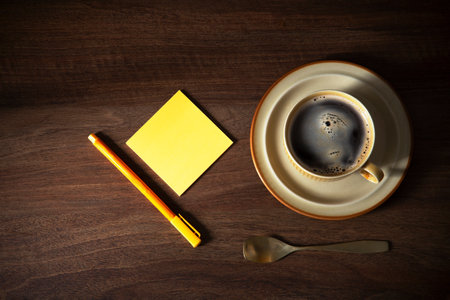 cup of coffee with paper on dark wooden backgroundの写真素材