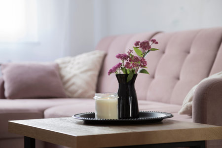 living room with pink flowers in black vase on tray