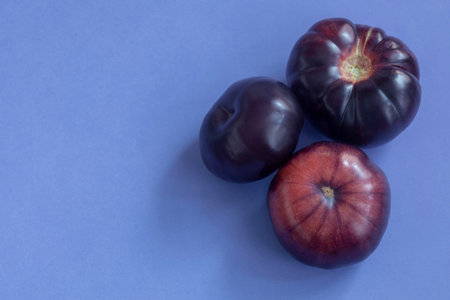 purple tomatoes on blue background top viewの写真素材