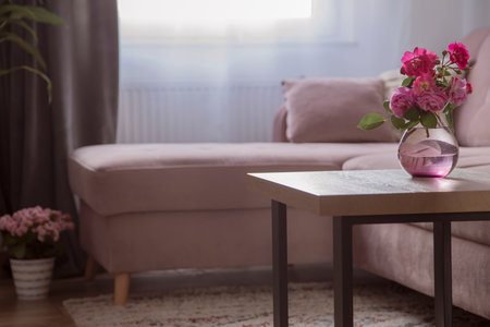 cozy interior with pink roses in glass vaseの写真素材