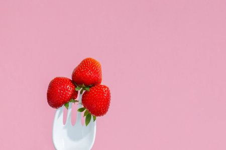 red ripe strawberries on a large plastic forkの写真素材