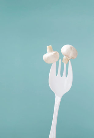 champignon on big white fork on green backgroundの写真素材