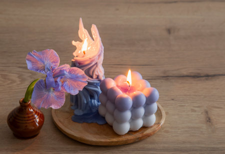 blue iris with burning candles on wooden tableの写真素材