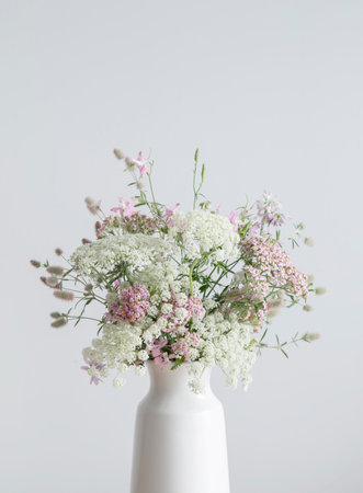 white and pink flowers in white vase on background white wallの写真素材