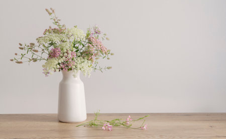 white and pink flowers in white vase on background white wallの写真素材