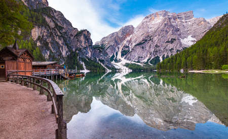 path around iconic mountain lake Pragser Wildsee (Lago di Braies) in Dolomites, South Tyrol, Italy Mount Seekofel and boatshouse mirroring in the clam clear waterのeditorial素材