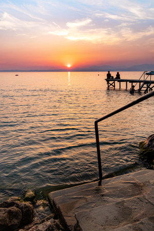 Lakeview at sunset from walkway at Cisano, Bardolino, Lake Garda, Italyの写真素材