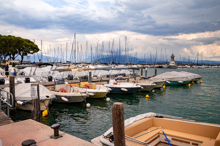 Desenzano, Lake Garda, Italy - 25 May 2024 Colorful motor- and sailingboats and lighthouse at harborのeditorial素材
