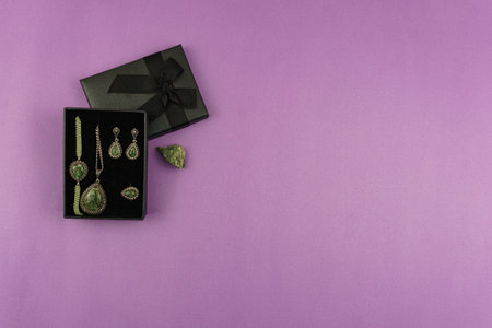 Chrysolite jewelry set in black gift box on pink backdrop. Perfect for social media and greeting cards designの写真素材