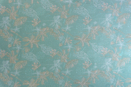Medium-weight upholstery fabric texture in sage green shade with tropical leaf pattern and lurex...