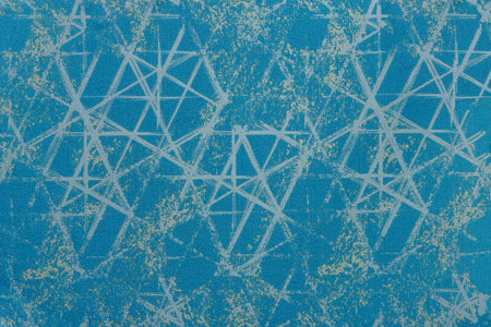 Woven fabric background featuring an abstract ornament of white intersecting lines and golden foil...