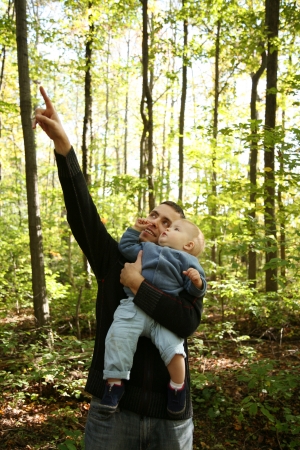 Father is teaching son about nature in the forest の写真素材