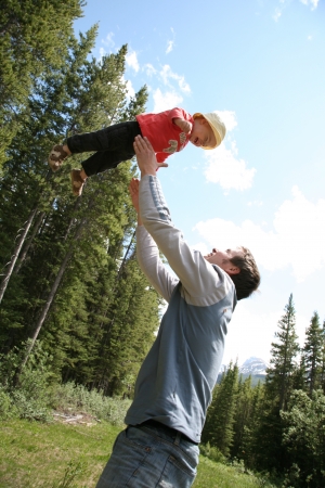 Father is playing with child outside in a parkの写真素材