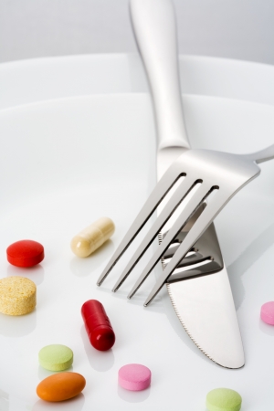 Fork, knife and many pills on a plateの写真素材