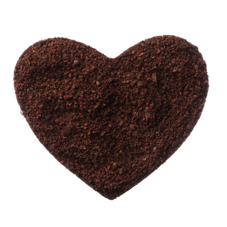 Ground coffee heart isolated on white background close upの写真素材
