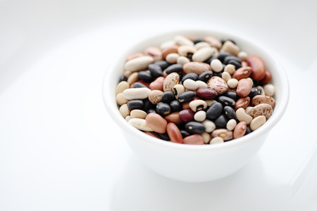 Assorted dried beans in a bowl isolated on white backgroundの写真素材