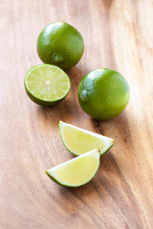 Green limes on a cutting board, close upの写真素材