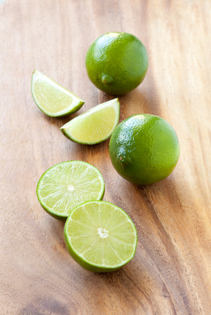 Green limes on a cutting board, close upの写真素材