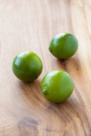 Green limes on a cutting board, close upの写真素材
