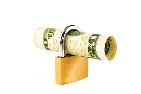 Safe money concept - rolled up inside a lockの写真素材