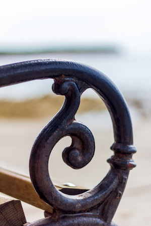 Armrest of a bench in front of the seaの写真素材