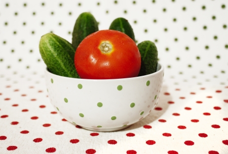 fresh cucumbers and tomato isolated on homey backgroundの写真素材