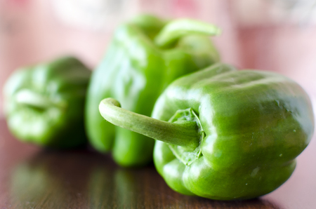 Green paprika / pepper on wooden broun table. Close up. Blur dark backgroundの写真素材