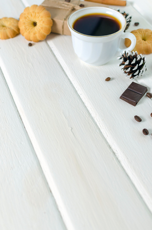 White cup of hot coffee with couple of croissants and chocolate. White wooden background.の写真素材