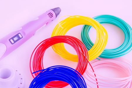 Top view on 3d pen, plastic filament. Pink toned background. 3d painting. Pink toned background.の写真素材