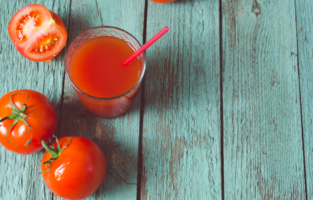 Tomato juice in glass with fresh tomatoes and salt. Rustic wooden background. Selective focus.の写真素材