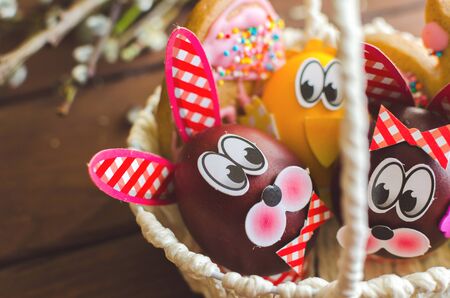 Easter eggs in the nest on rustic wooden background. Handmady bunnyの写真素材