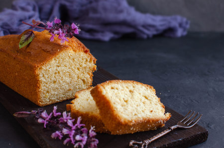 Lemon pound cake on dark stone background with lemon. Selective focus