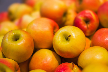 Red and orange apples background full of oranges. Fresh red apple on the market, close up
