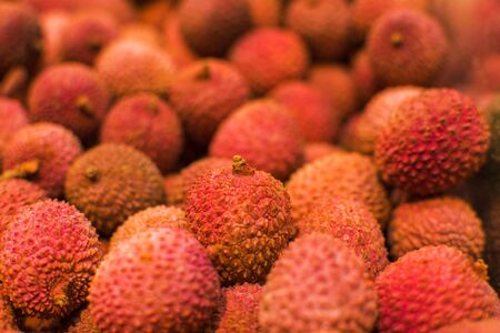 Tropical fruit lychee. Fresh raw organic lychee fruit for sale at farmers market or shop. Vegan food, healthy nutrition, fruit. Raw Red Organic Lychee Fruit Ready to Eatの写真素材