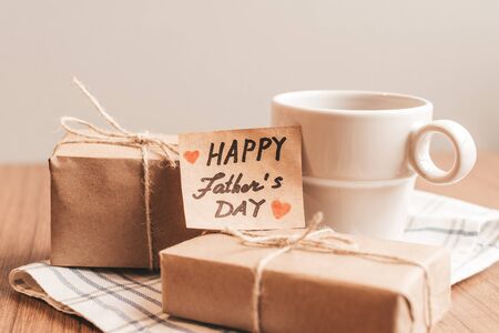 Gift box with a tag, cup of coffee or tea. Father's day or birthday concept. Pastel colors.の写真素材