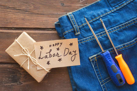 USA Labor day concept. Different kinds on wrenches, handy tools, tag on blue jeans background.の写真素材