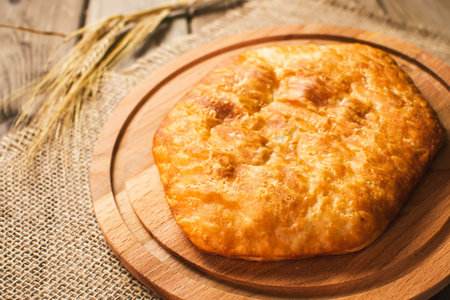 Italian food, closed pizza calzone with Spinach and Cheese, wooden background