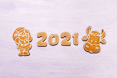 Happy New Years set of numbers 2021, gingerbread santa claus and symbol of year from ginger biscuits glazed sugar icing decoration on light backgroundの写真素材