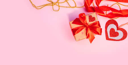 Valentines Day or birthday presents. Valentines Day gifts with a red paper heart on a pink background. Top view. Pink background. Handicraft gifts.の写真素材