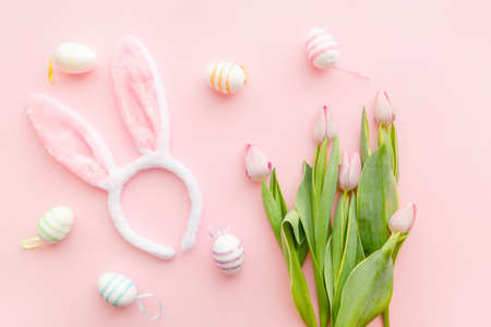 Bunny ears and pink tulips on pink backround on Easter day. Celebrating Easter at spring. colorful eggs.の写真素材