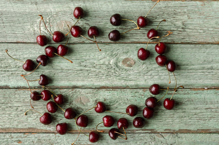 Close up of fresh cherry berries with water drops. Frame made from cherries.
