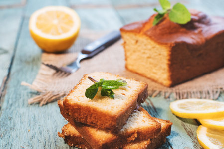 Lemon pound cake on rustic wooden background with lemon.