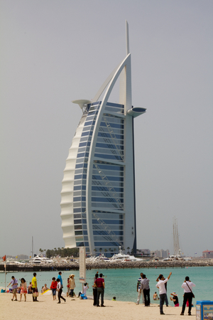 DUBAI, UAE - APRIL 16, 2012: Tourists at the Jumeirah beach with Burj Al Arab hotel in the backgroundのeditorial素材