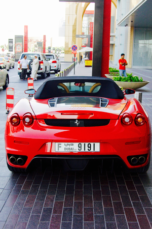 DUBAI, UAE - SEPTEMBER 23, 2012: A red convertible Ferrari car parked outside The Dubai Mallのeditorial素材
