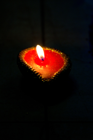 An oil lamp (diya) on a dark background during Diwali celebrations in India. Diwali is one of the biggest Indian festivals celebrated every year in Indiaの写真素材