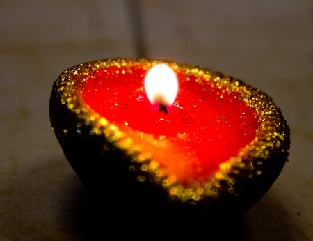 Close up of a lit oil lamp (diya) during Diwali celebrations in India. Diwali is one of the biggest Indian festivals celebrated every year in Indiaの写真素材